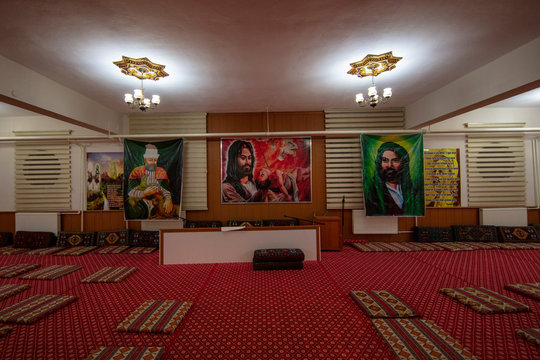 Landscape photo of the Green Drawing Room in Buckingham Palace; royal gold and red carpet, green panelled walls with large portraits hanging, high ceilings decorated in gold, green and gold furniture in the room